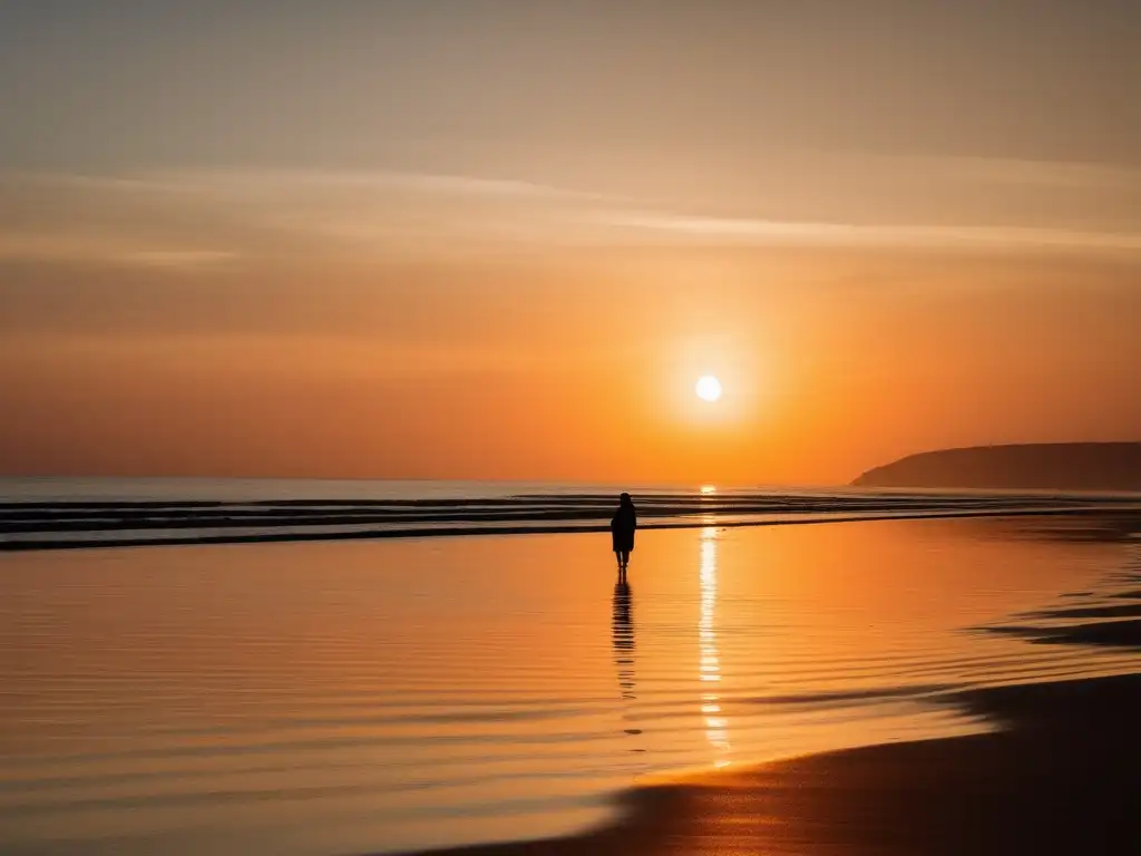 Una playa serena al amanecer con olas suaves y una persona solitaria contemplando el mar